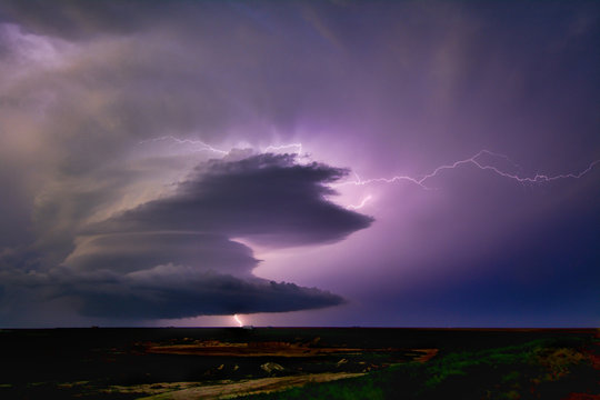 Lightning sparks from a spinning supercell thunderstorm at night near Leoti, Kansas