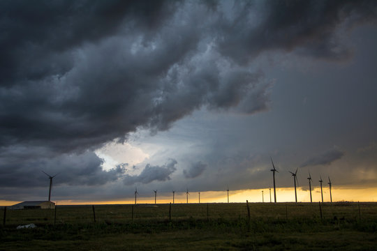 Severe storms threaten near wind turbines at sunset, south of Dumas, Texas