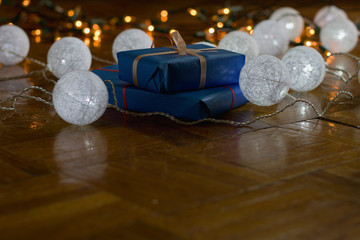 Christmas gifts with decorations and christmas lights as background, gift boxes with ribbon 