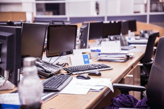 Long office desk with rows of desktop computers