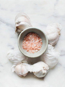 Garlic bulbs and pink sea salt in bowl