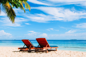 Obraz na płótnie Canvas Two beach chairs on tropical vacation
