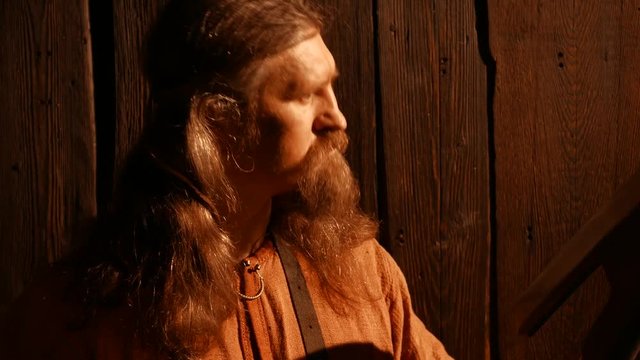 Senior blacksmith checks ax blade in smithy