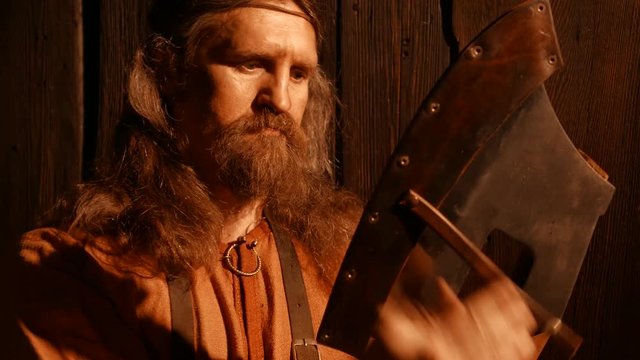 Senior blacksmith puts an ax leather cover