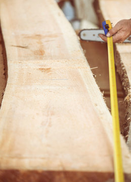 Carpenter measuring wooden plank