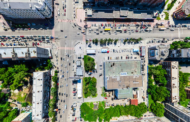 Obraz premium Aerial city view with crossroads and roads, houses, buildings, parks and parking lots, bridges. Urban landscape. Copter shot. Panoramic image.