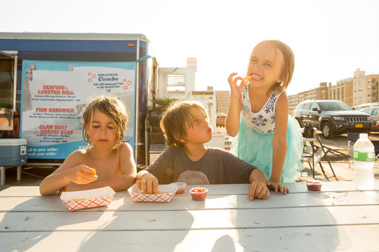 Group of children eating fast food beside fast food trailer