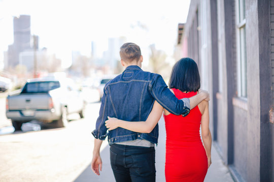 Young couple walking on sidewalk