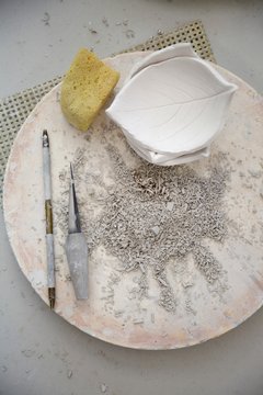 Leaf shaped modelling clay carving, with modelling tools, overhead view