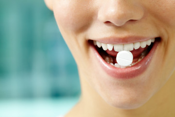 Female teeth holding a pill