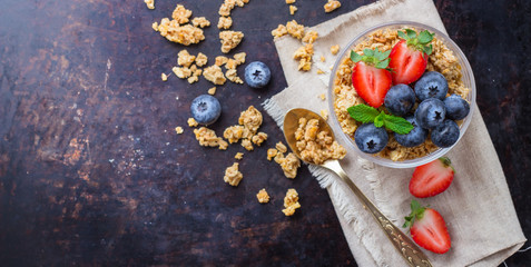 Obraz na płótnie Canvas Homemade muesli granola in glass with berries on rusty table