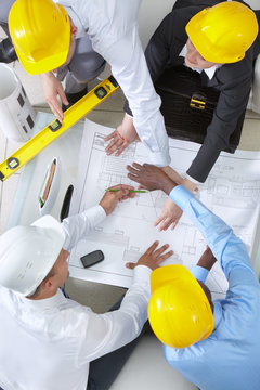 High angle view of four engineers discussing a housing project
