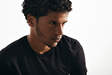 Obraz premium Moody thoughtful black young model wearing a blank black t-shirt isolated on white