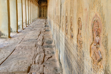 Obraz premium Dancing Apsaras an old Khmer art carvings on the wall in the corridors of Angkor Wat temple near Siem Reap town, Cambodia. Selective focus on nearest bas-relief