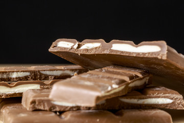 Chocolate tablets with fruit taste fillings on black background