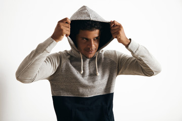 Attractive black man wears hoodie on his head with curly hair , looking miraculously on side, isolated on white