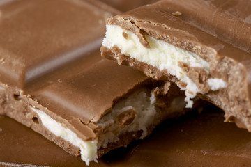 Detail of bitten chocolate bars with fruit taste filling. Food background