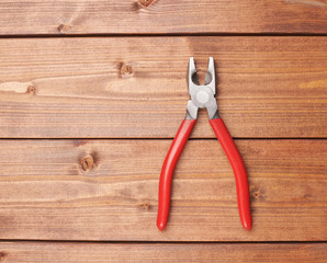 Lineman's combination pliers hand tool on wooden surface