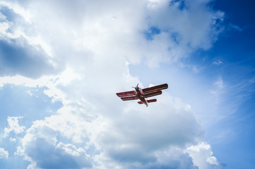 Roter Doppeldecker/Flugzeug fliegt vor blauem Himmel