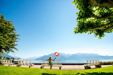 Beautiful landscape view on the park and mountains near Geneva lake with woman sitting on the bench in Switzerland