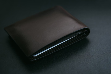 Close Up Classic dark brown leather wallet on black leather background