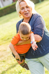 Portrait of happy grandmother with grandson playing outdoor