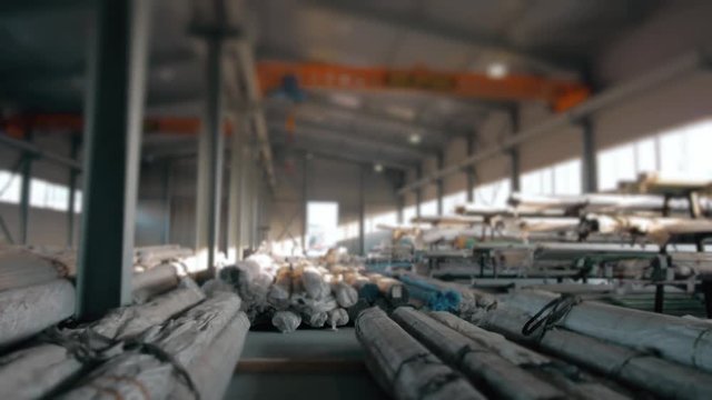 Steel Pipes bunch on the rack in warehouse. Modern stock of Equipment on sunset witj lens frares