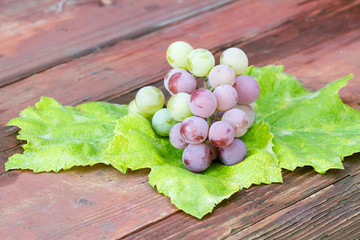 Fresh grapes on the vintage wooden background