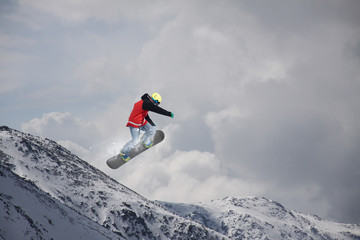 Flying snowboarder on mountains. Extreme sport.