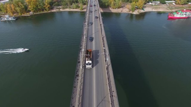 Flying over the bridge at Samara river. Car traffic at bridge.  Drone moving backwards. 4K Aerial stock footage clip.
