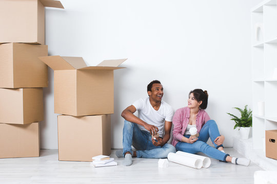 Young Couple In A New House Planning Decoration Moving Home.