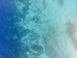 Aerial shot of blue ocean and coral reef