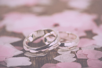 wedding rings on a wooden background with confetti Vintage Retro