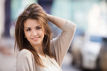 Portrait of beauty woman with perfect smile walking on the street and looking at camera