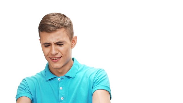Surprised young man grab his head smiling over white background Slow motion
