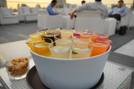rainbow cocktail shotes serve in ice bucket in evening twilight nature light with background as business men hangout with friends - backlight pic.