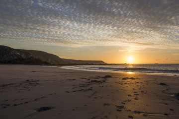 Kennack sands beach at sunrise with sandy beach and beautiful cloudy sky, Cornwall, UK