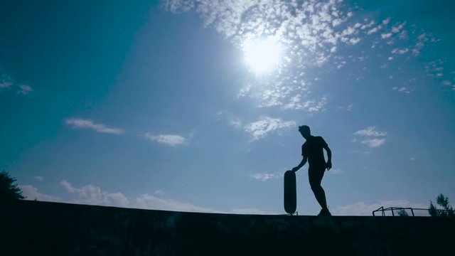 Artistic skater silhouette at sunset. Super slow motion. HD.