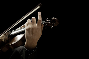 The violin in the hands of a musician closeup on a black background