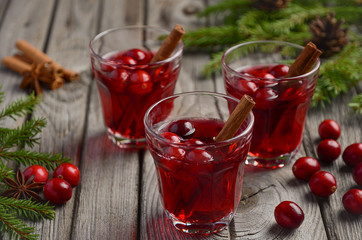 Cranberry drink on wooden background with fir branches and fresh berries, selective focus