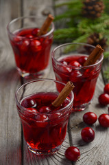 Cranberry drink on wooden background with fir branches and fresh berries, selective focus
