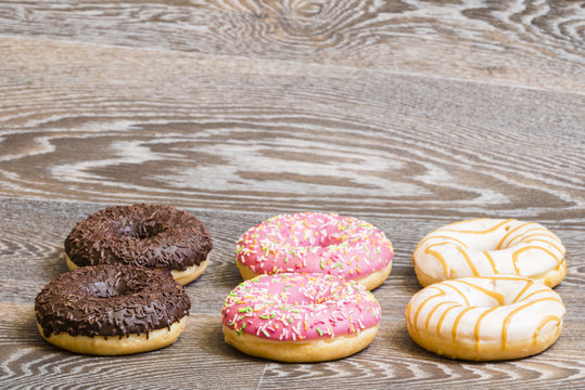 Hand decorated donuts on a wooden background