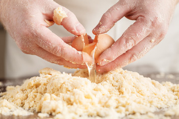 handful of flour with egg on a rustic kitchen. Against the backg