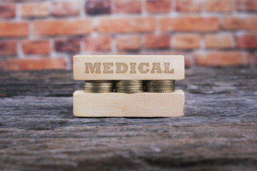 Business Concept - MEDICAL word Golden coin stacked with wooden