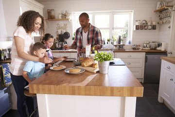 Family At Home Eating Breakfast In Kitchen Together - Powered by Adobe