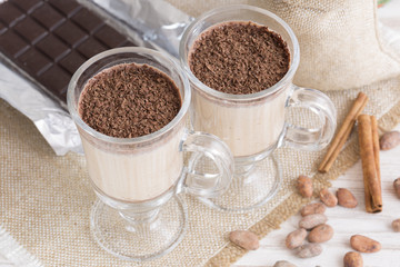 Fresh Made Chocolate Banana Smoothie on a wooden table with coffee and spices. Milkshake. Protein diet. Healthy food concept. Drink, cocoa beans, chocolate.