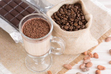 Fresh Made Chocolate Banana Smoothie on a wooden table with coffee and spices. Milkshake. Protein diet. Healthy food concept. Drink, cocoa beans, chocolate.