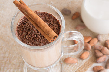 Fresh Made Chocolate Banana Smoothie on a wooden table with coffee and spices. Milkshake. Protein diet. Healthy food concept. Drink, cocoa beans, chocolate.