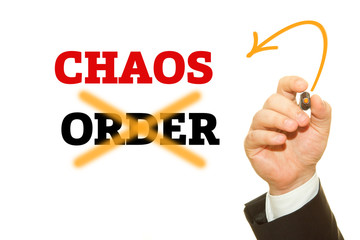 Hand writing CHAOS and ORDER word on a transparent wipe board.