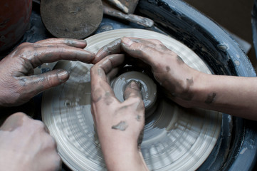 Woman's hands making ceramic cup on potter's wheel